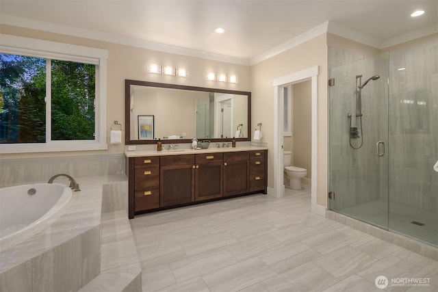 bathroom featuring a shower stall, toilet, vanity, a garden tub, and crown molding