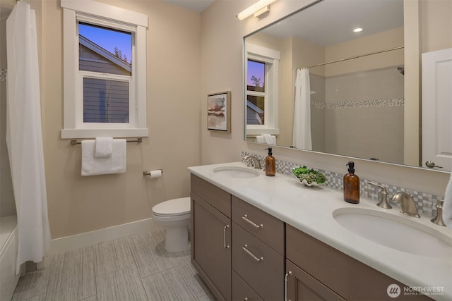 full bath featuring baseboards, toilet, and double vanity