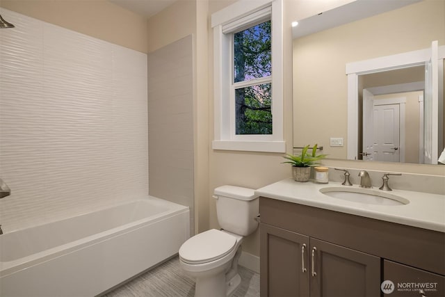 bathroom with toilet, vanity, baseboards, and bathtub / shower combination