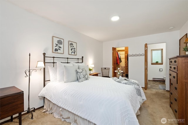 bedroom featuring a closet, carpet flooring, baseboards, and a walk in closet