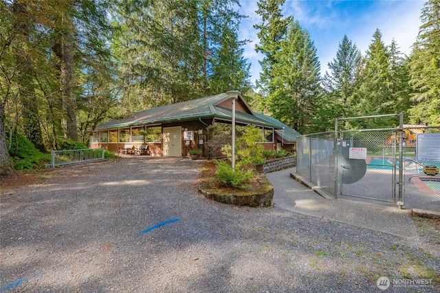 view of parking / parking lot with fence, a gate, and driveway