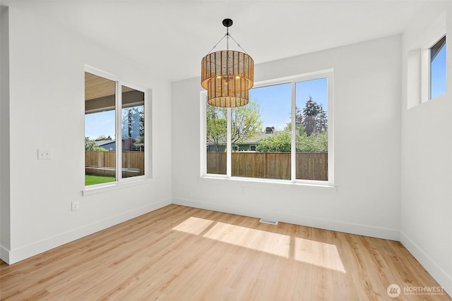 1322 114th St S, Tacoma, WA 98444 - unfurnished dining area with baseboards, wood finished floors, a notable chandelier, and a wealth of natural light