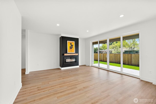 1322 114th St S, Tacoma, WA 98444 - unfurnished living room featuring a glass covered fireplace, baseboards, light wood-style floors, and recessed lighting