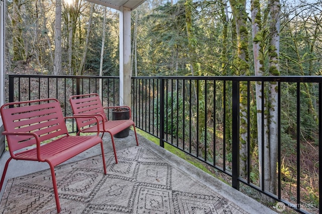 balcony featuring a forest view