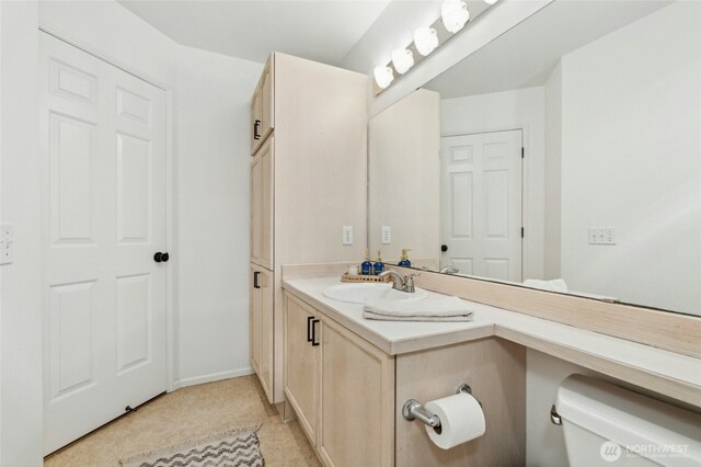 half bathroom with vanity and toilet