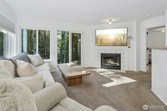 living area featuring carpet floors, baseboards, and a fireplace