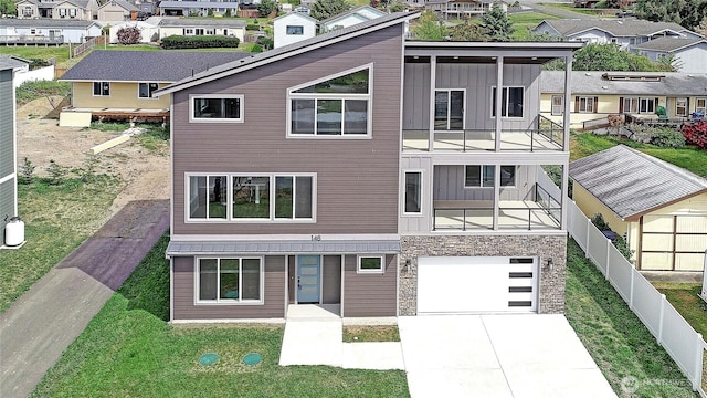148 Henning Dr, Camano Island, WA 98282 - view of front of house featuring a residential view, board and batten siding, a balcony, an attached garage, and stone siding