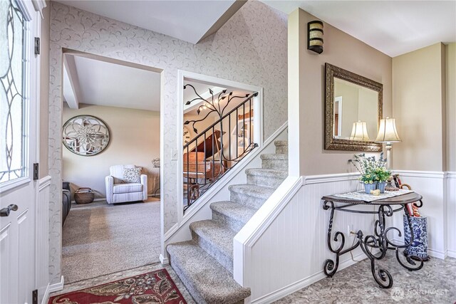 entrance foyer with a wainscoted wall and stairs