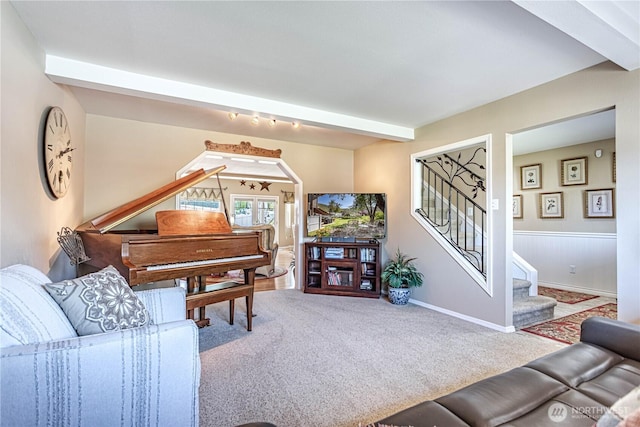 carpeted living area featuring baseboards and stairs