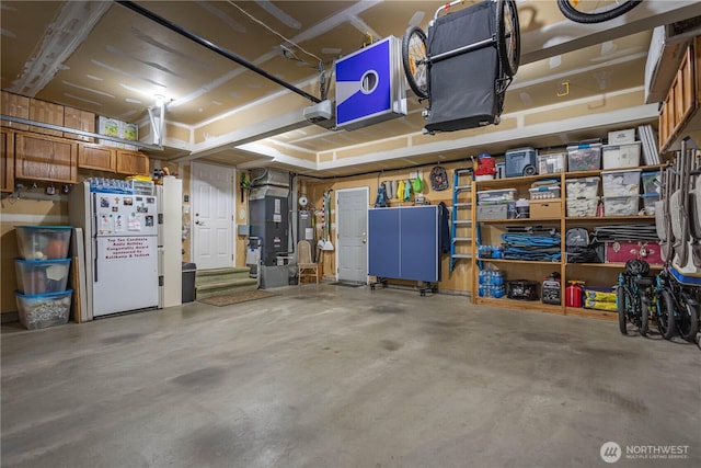 garage featuring heating unit and freestanding refrigerator