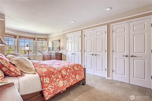 carpeted bedroom with recessed lighting and multiple closets