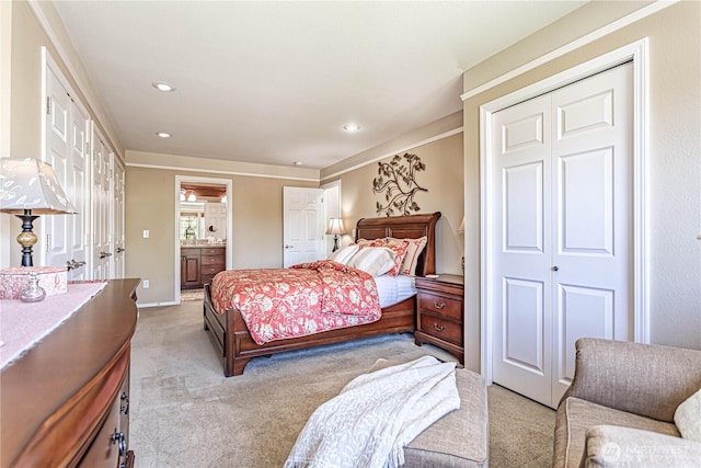 bedroom featuring recessed lighting, a closet, light colored carpet, and ensuite bath