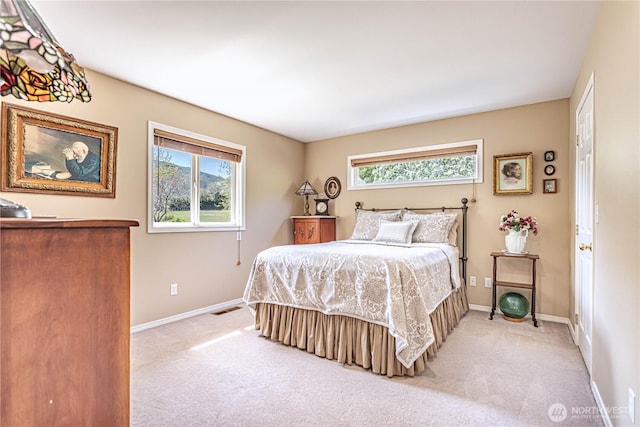 bedroom featuring light colored carpet, visible vents, and baseboards