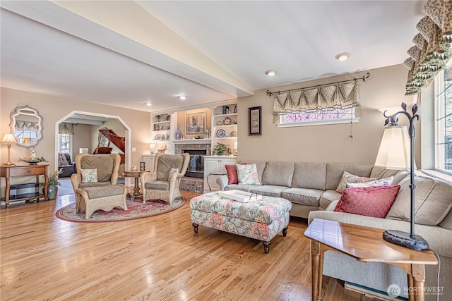 living room featuring wood finished floors, plenty of natural light, and vaulted ceiling