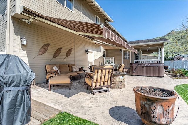 view of patio with fence, an outdoor hangout area, and a hot tub