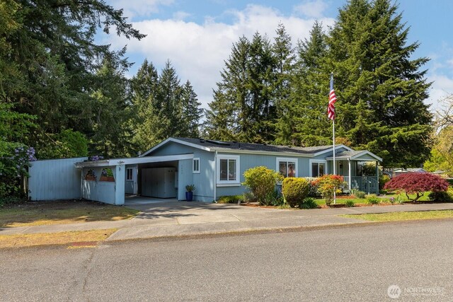 ranch-style house with fence, an attached carport, and driveway