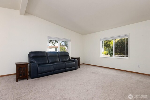 living room featuring baseboards, lofted ceiling with beams, and plenty of natural light