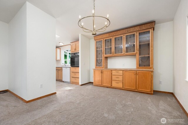 unfurnished dining area featuring an inviting chandelier, baseboards, and light carpet
