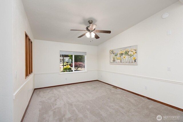 spare room featuring baseboards, ceiling fan, carpet, and lofted ceiling