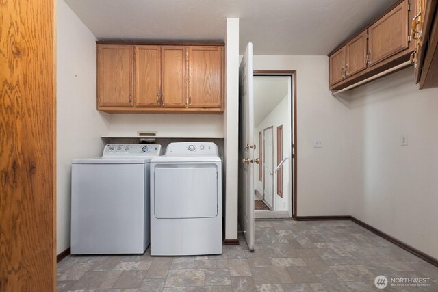 washroom featuring baseboards, stone finish flooring, cabinet space, and independent washer and dryer