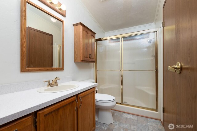 bathroom with crown molding, vanity, toilet, stone finish flooring, and a stall shower