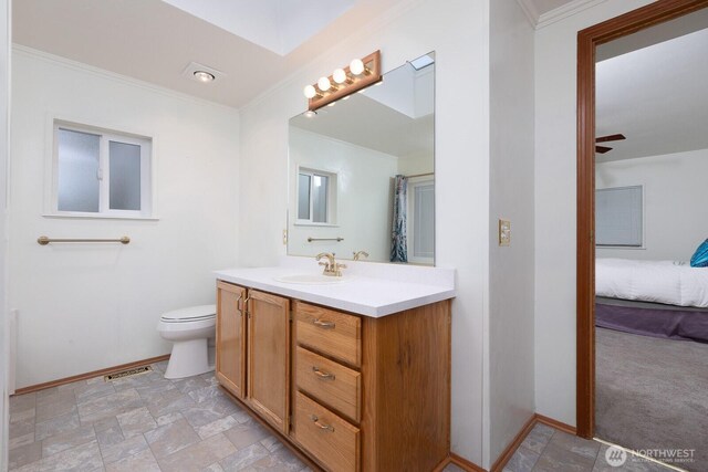 full bathroom featuring crown molding, vanity, baseboards, stone finish floor, and connected bathroom