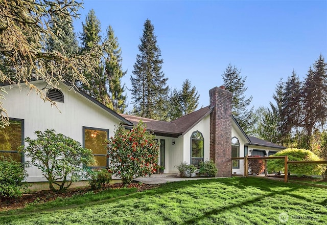 exterior space featuring a chimney and a front lawn