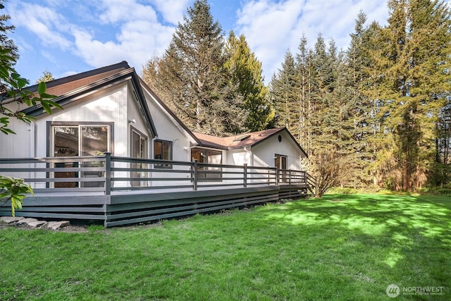 back of property featuring a deck and a yard