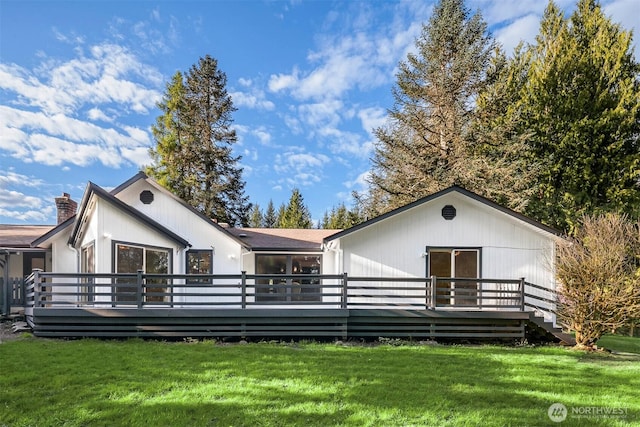 view of front of property featuring a chimney, a wooden deck, and a front yard