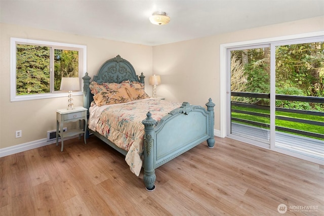 bedroom featuring wood finished floors, visible vents, access to exterior, and baseboards