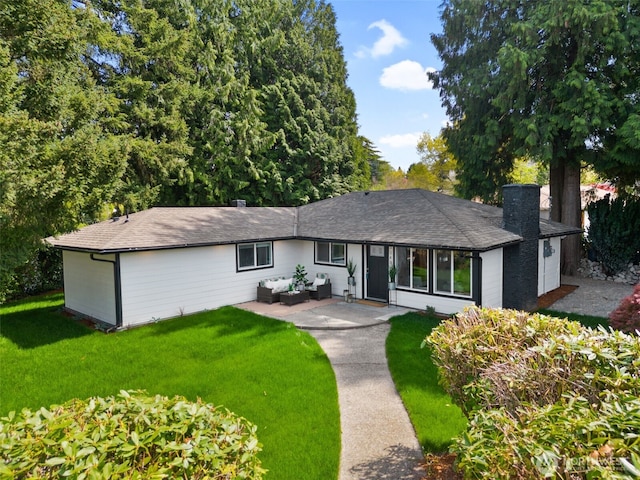 ranch-style home featuring a chimney, a front lawn, outdoor lounge area, and an attached garage
