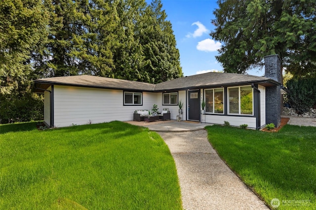 ranch-style home with a chimney, a patio, and a front lawn