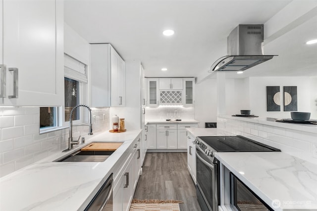 kitchen with range hood, a sink, stainless steel range with electric stovetop, backsplash, and white cabinetry