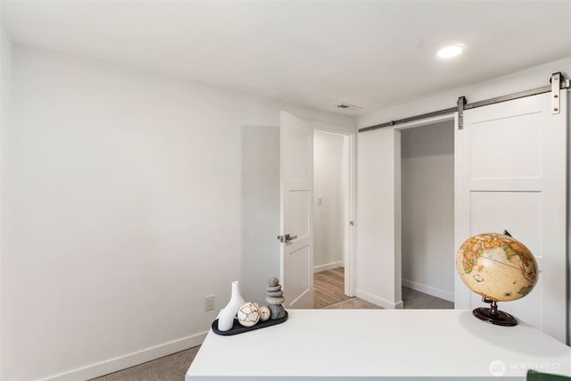 bedroom with visible vents, a barn door, a closet, baseboards, and recessed lighting