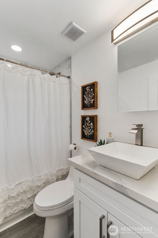 full bathroom featuring recessed lighting, vanity, toilet, visible vents, and wood finished floors