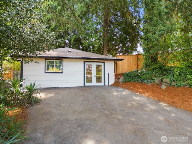 back of property with french doors and fence