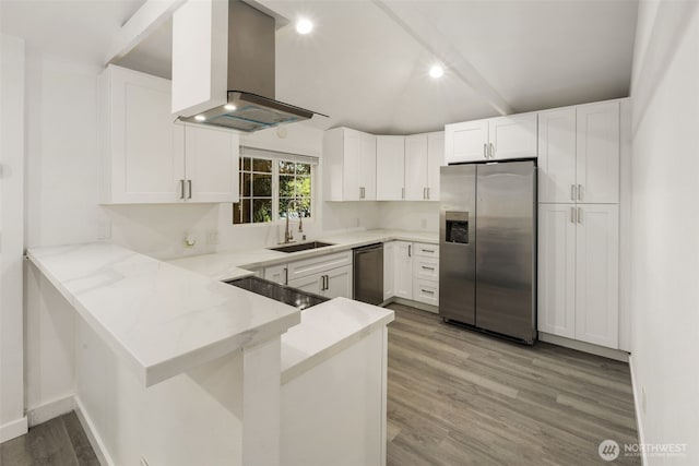 kitchen with a sink, island exhaust hood, light wood-style flooring, a peninsula, and appliances with stainless steel finishes