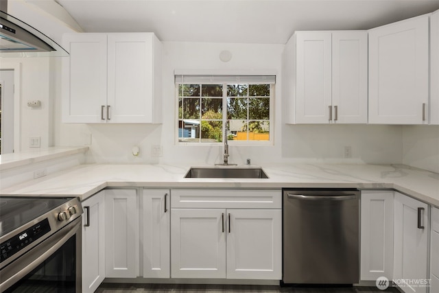 kitchen with appliances with stainless steel finishes, white cabinetry, light stone countertops, and a sink