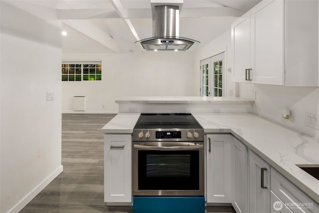 kitchen with island range hood, light stone counters, a peninsula, baseboards, and stainless steel electric stove