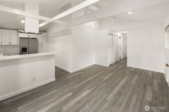 below grade area featuring recessed lighting, stainless steel refrigerator with ice dispenser, wood finished floors, and baseboards