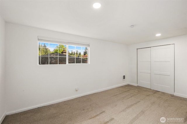unfurnished bedroom with visible vents, a closet, baseboards, recessed lighting, and carpet