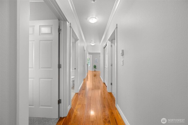 hall featuring baseboards and light wood finished floors