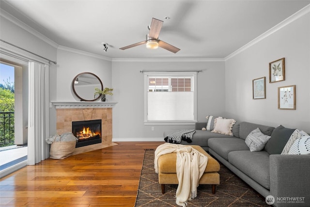 living area with a healthy amount of sunlight, ornamental molding, and hardwood / wood-style flooring