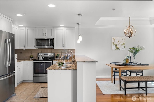 kitchen featuring decorative backsplash, appliances with stainless steel finishes, stone countertops, a peninsula, and recessed lighting