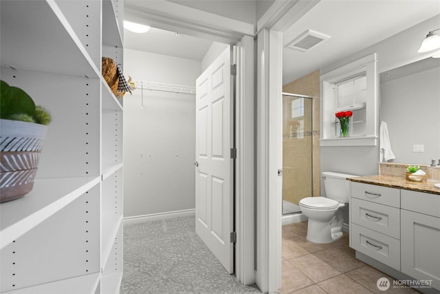 interior space with vanity, toilet, a spacious closet, visible vents, and a stall shower