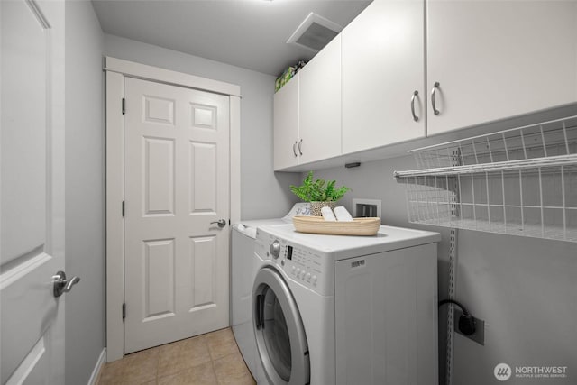 laundry room with visible vents, cabinet space, light tile patterned floors, baseboards, and washer / dryer
