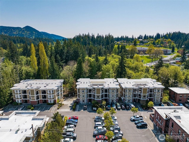 drone / aerial view with a mountain view and a wooded view