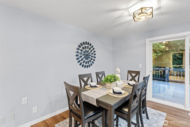 dining area with baseboards and wood finished floors