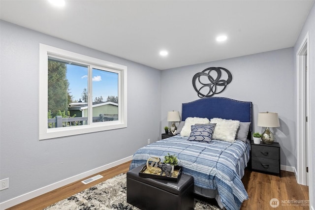 bedroom with baseboards, visible vents, wood finished floors, and recessed lighting