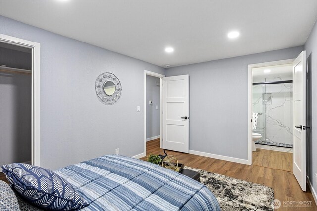 bedroom featuring a closet, baseboards, recessed lighting, wood finished floors, and ensuite bath